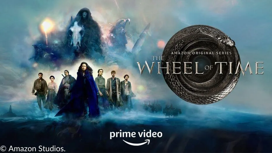 A promotional poster for The Wheel of Time Season 1 featuring the main cast standing together, with Moiraine in the center, dressed in blue. In the background, shadowy villains loom over a darkened landscape, including a Fade and Trollocs. The image includes the Prime Video logo and the show’s title with an ouroboros.